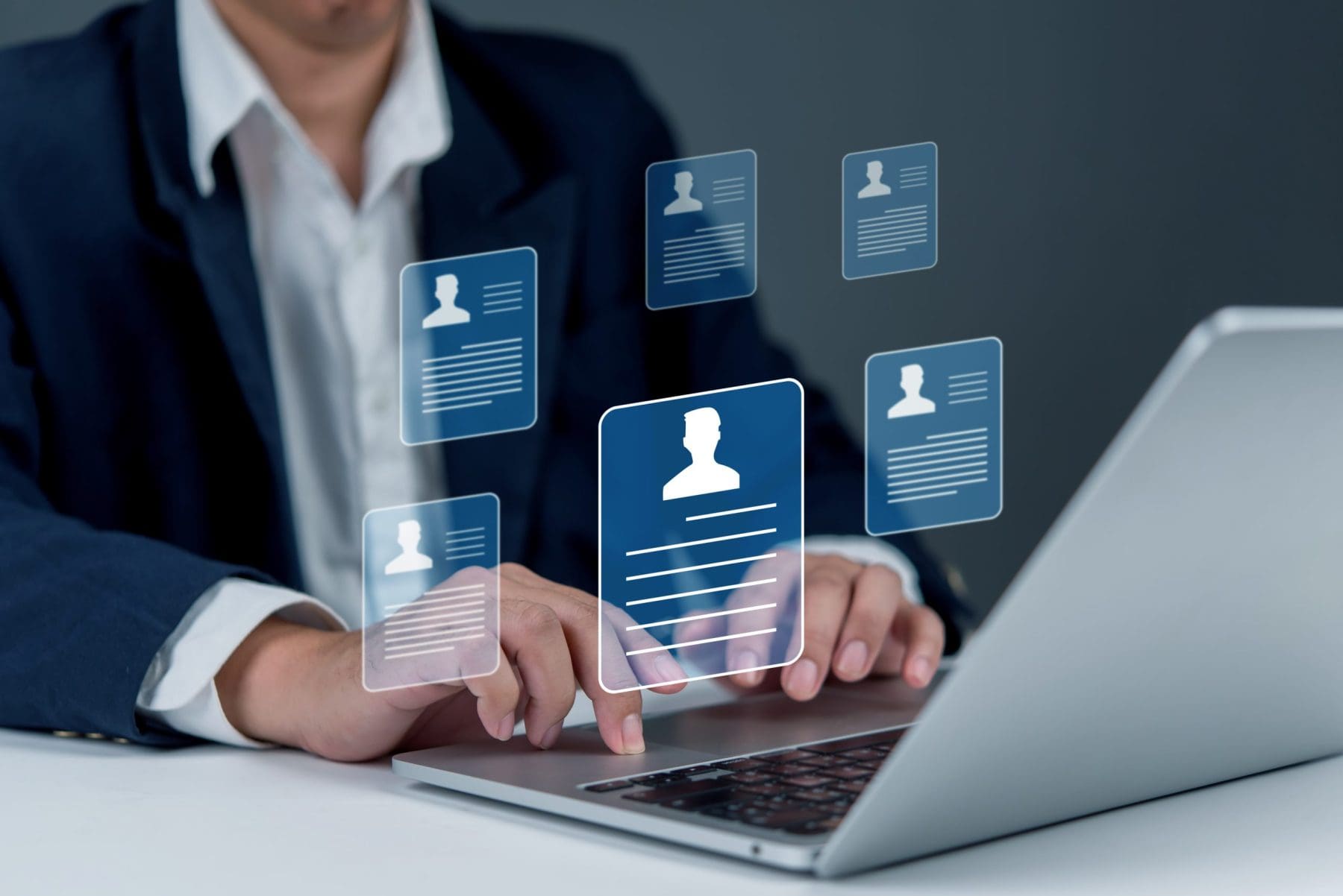 Man using laptop floating figures of people.