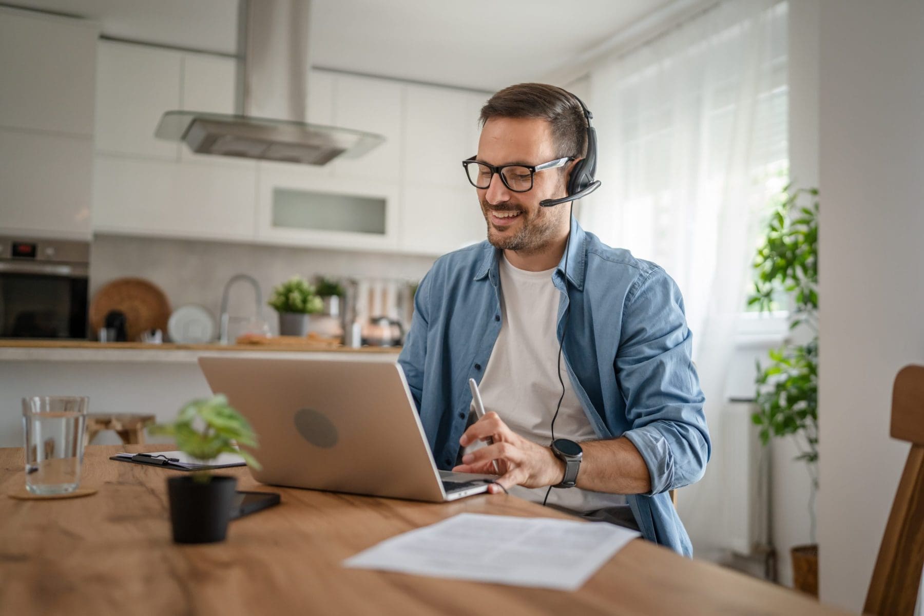 Man working from home using laptop and headset.