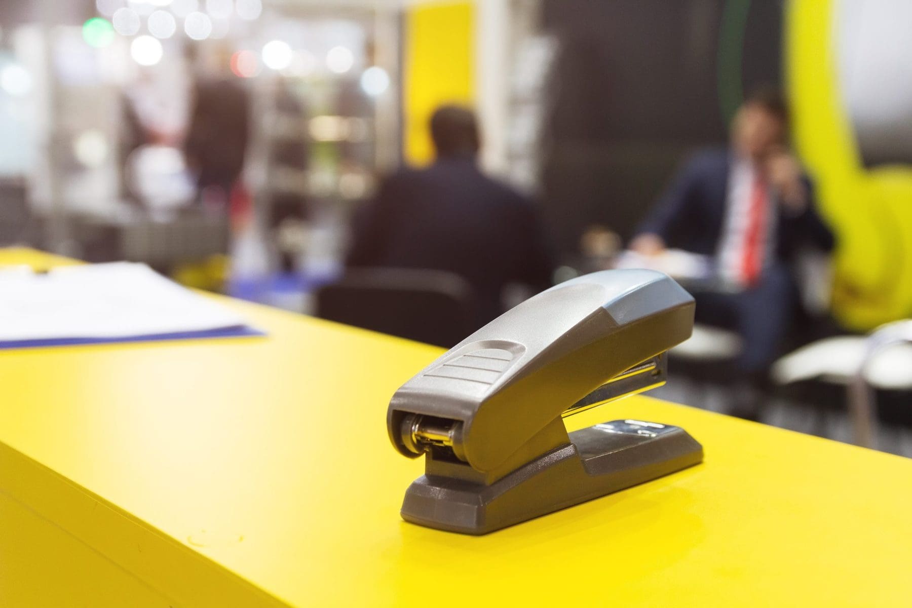 Black stapler on a table.
