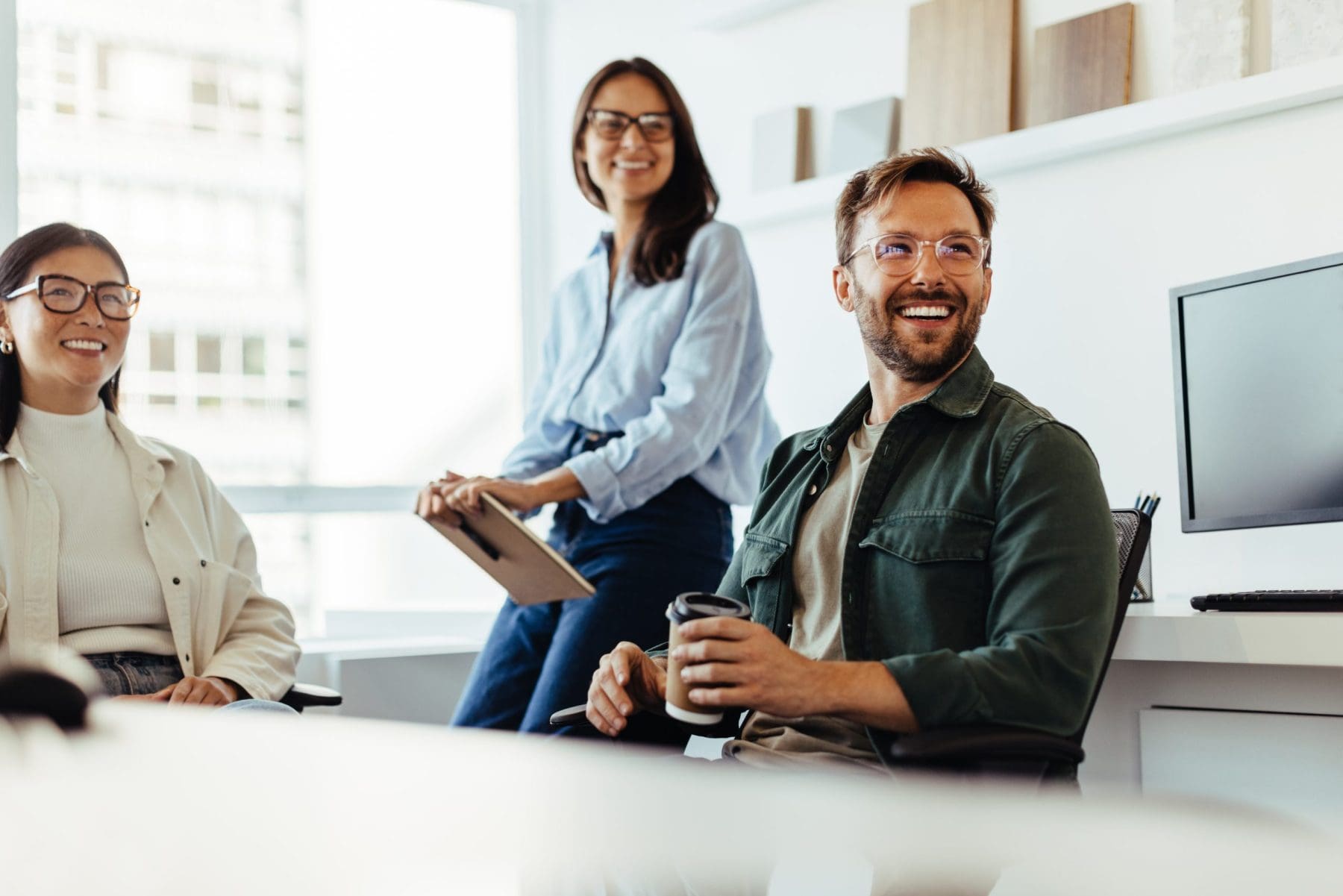 Side view portrait of smiling adult man using laptop while enjoying work in office.