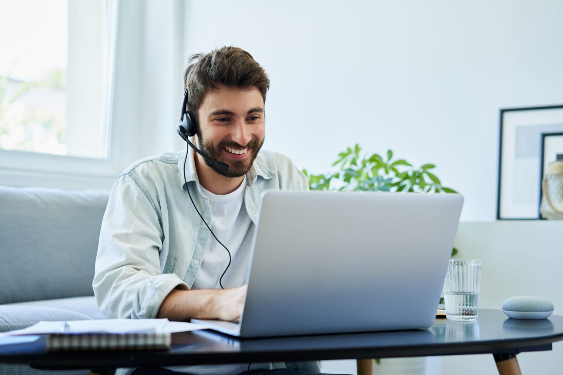 Young man with headset working on laptop.