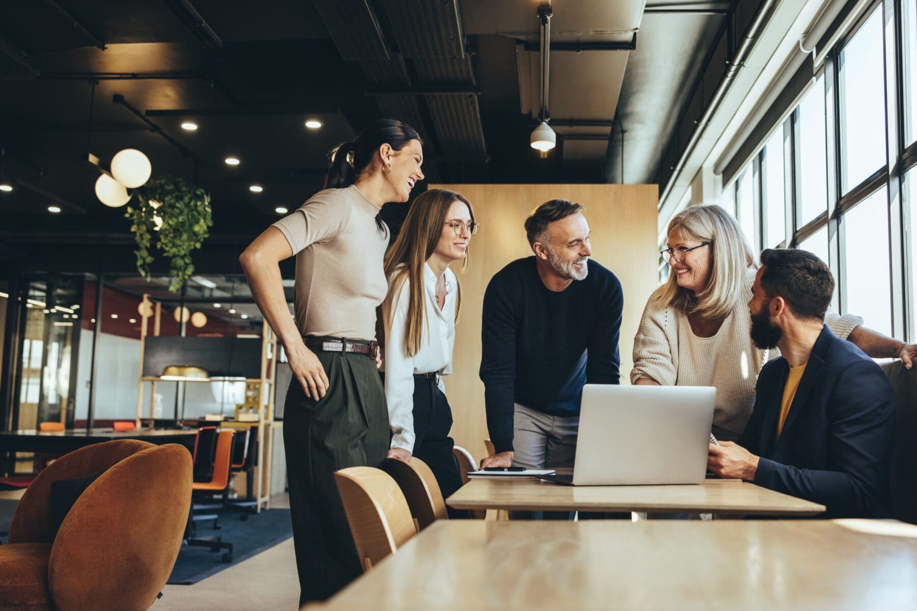 Smiling businesspeople having a discussion while collaborating on a project in an office.