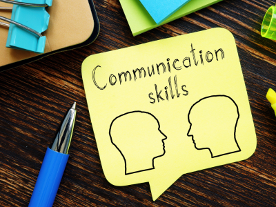 Sticky note with two head outlines and words: communication skills