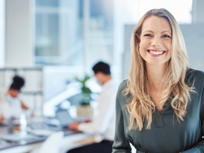 Woman smiling, team working at the background.