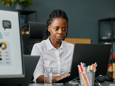 Woman with straight face working on computer.