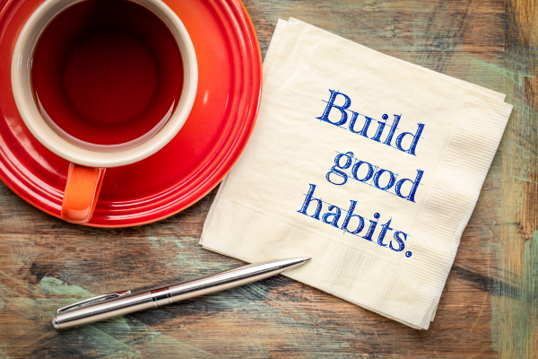 Cup of coffee and napkin with message: Build good habits.